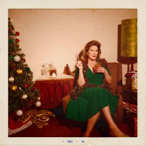 Ana Gasteyer holding a candy cane and a cocktail.